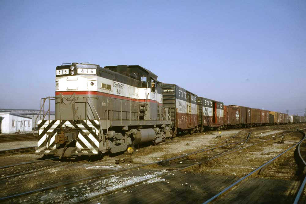 Gray and white diesel locomotive with freight train