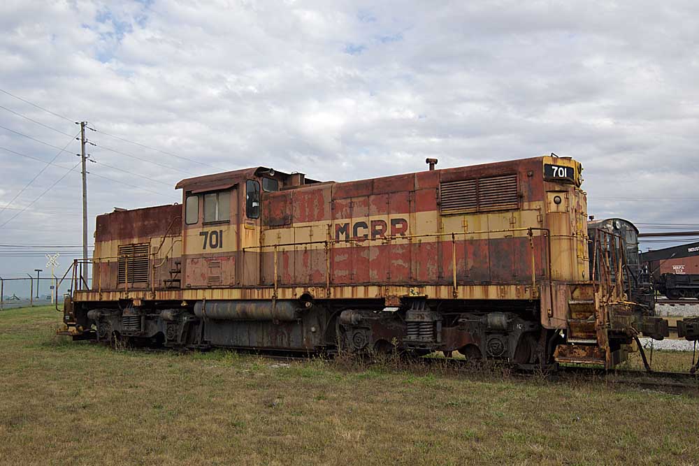 Rusted gray and yellow centercab diesel locomotive