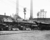 Articulated steam locomotive in front of factory building and smokestacks