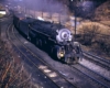 Steam locomotive leads freight train through curve by white tower