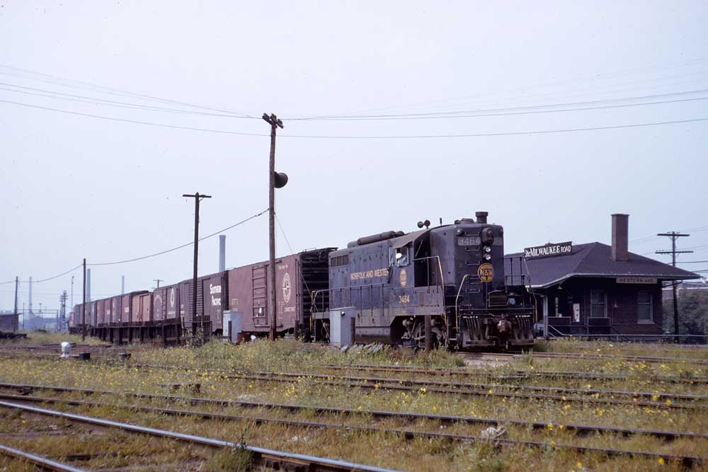 Blue diesel locomotive with train of maroon boxcars