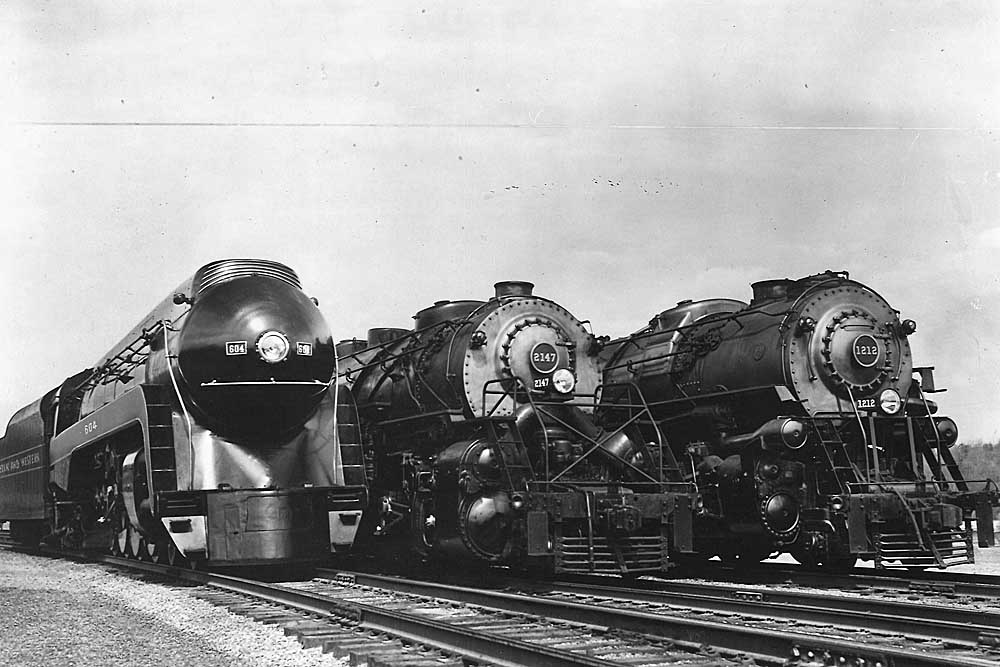 Three steam locomotives line up in the yard