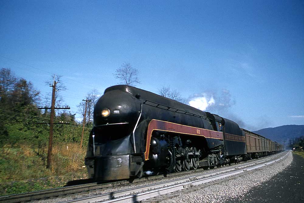 Streamlined steam locomotive with passenger train on curve
