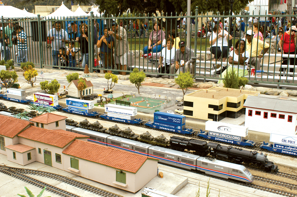 Crowd of people watching a garden railroad