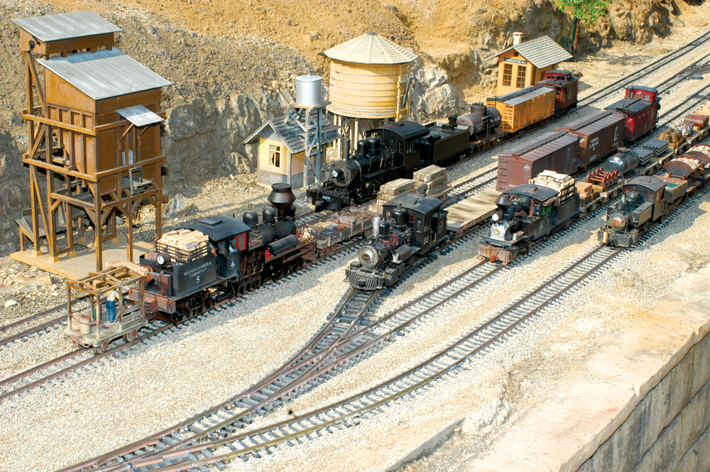 Four model steam locomotives on a garden railroad