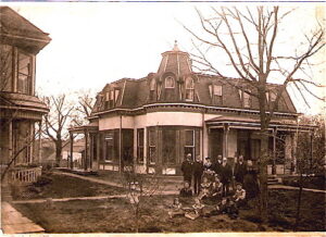 Sepia toned photo of house with people in front of it