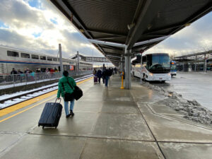 passenger with rolling suitcase walks on platform of station