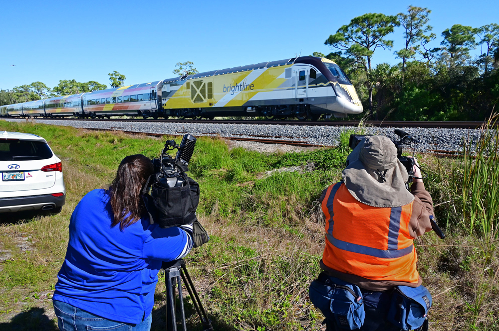Passenger train with TV cameramen in foreground