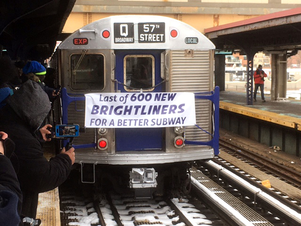 Subway car with banner on nose at station