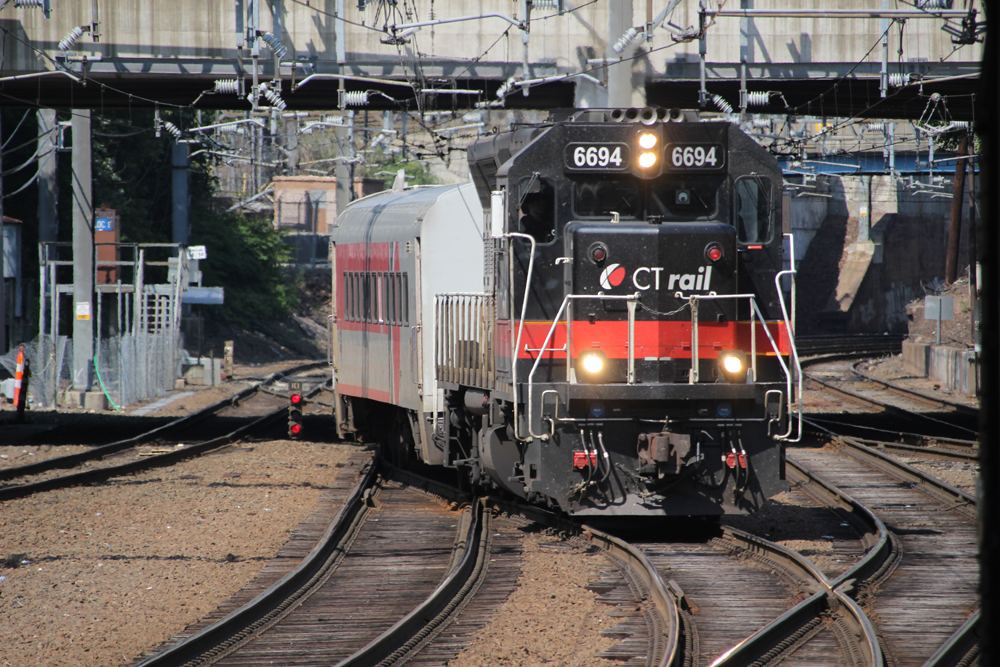 Black and red locomotive leads short passenger train