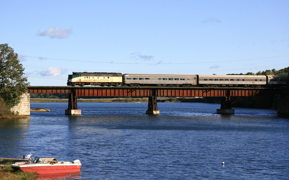 Passenger train with F unit crosses bridge