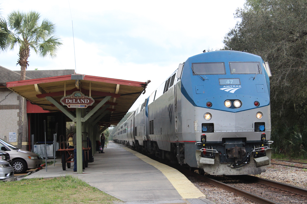 Passenger train with blue and silver locomotive at station