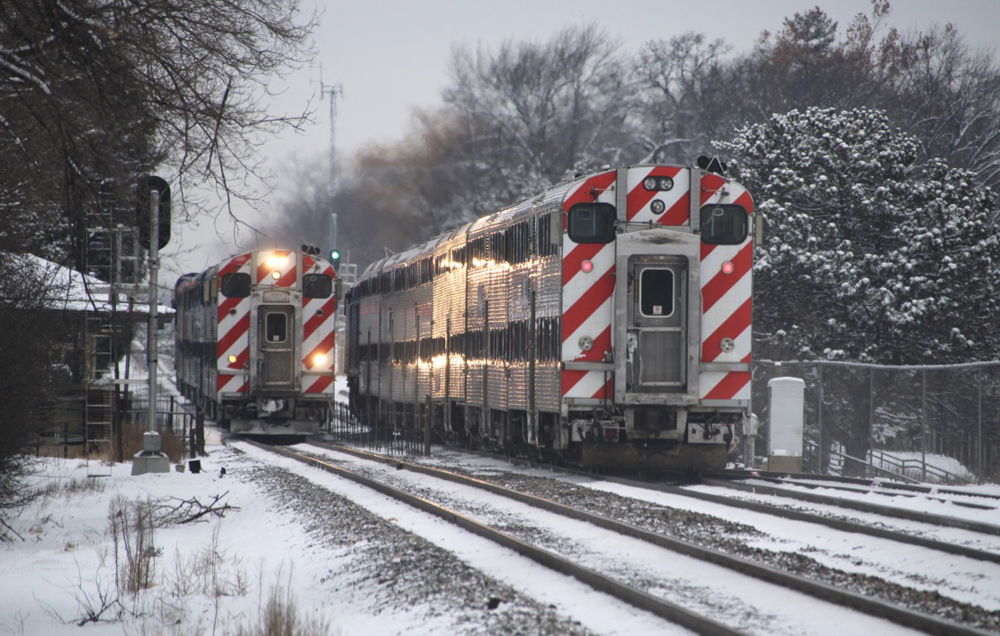 Commuter trains side-by-side at station in snow