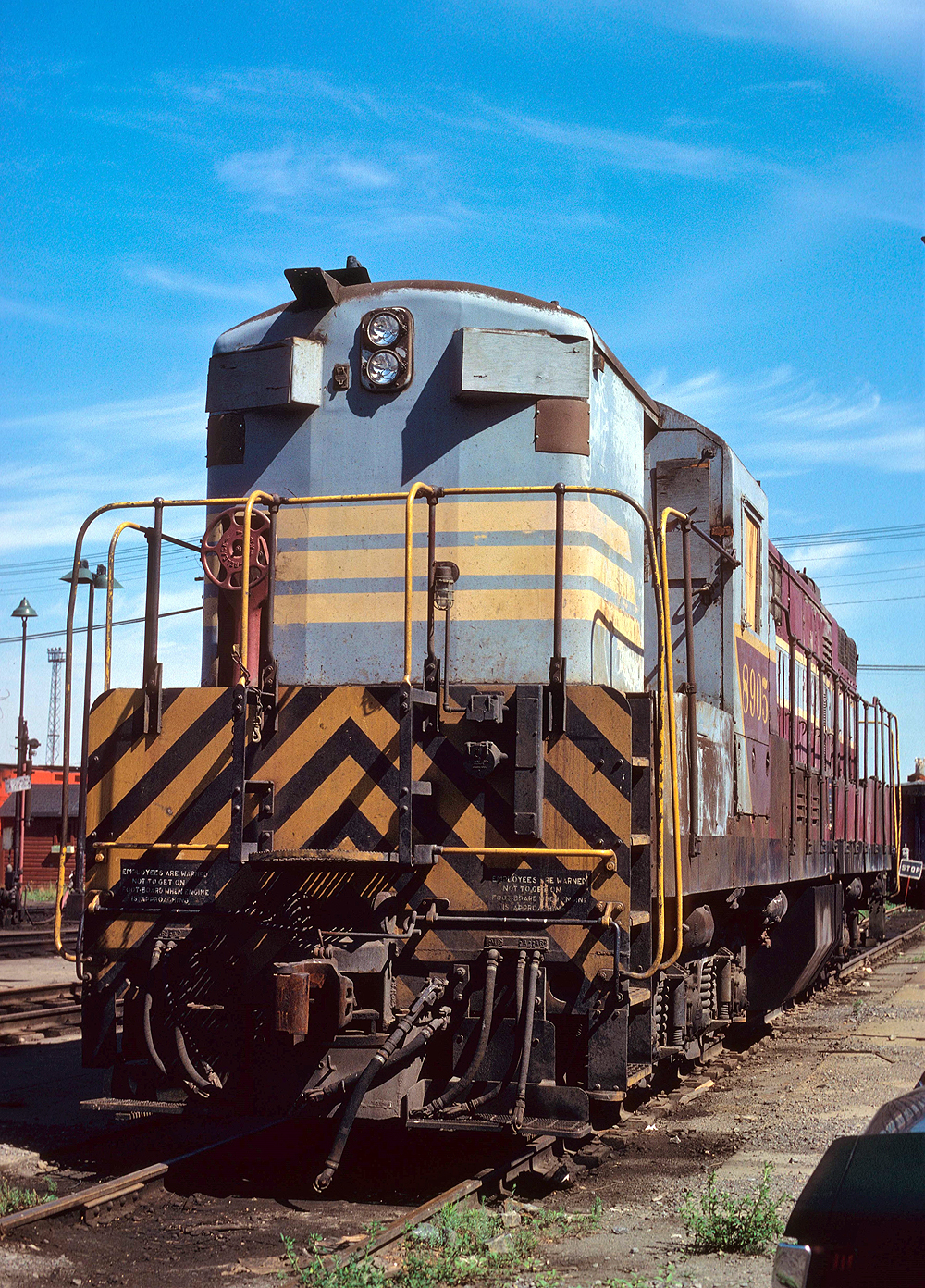 Maroon and gray diesel with high short hood.