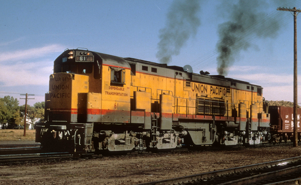 Large yellow eight-axle locomotive with red and gray trim.