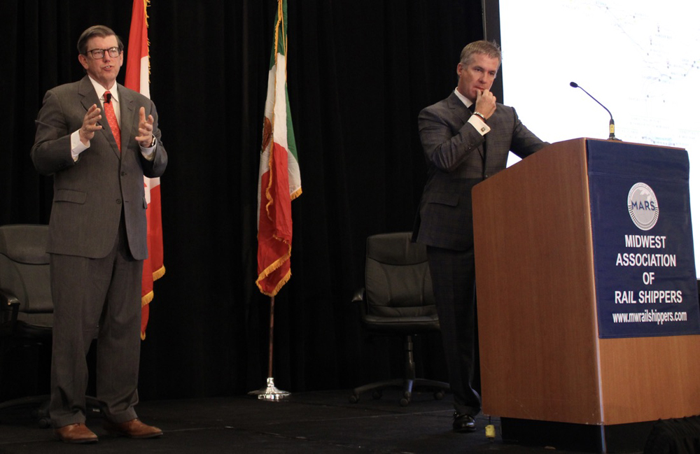 Two men on dais at conference