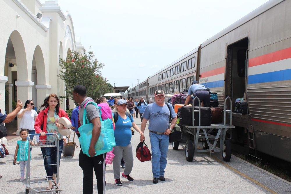 Passengers on platform with train stopped at station