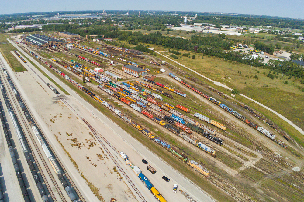 Aerial view of shop complex with dozens of locomotives in many paint schemes