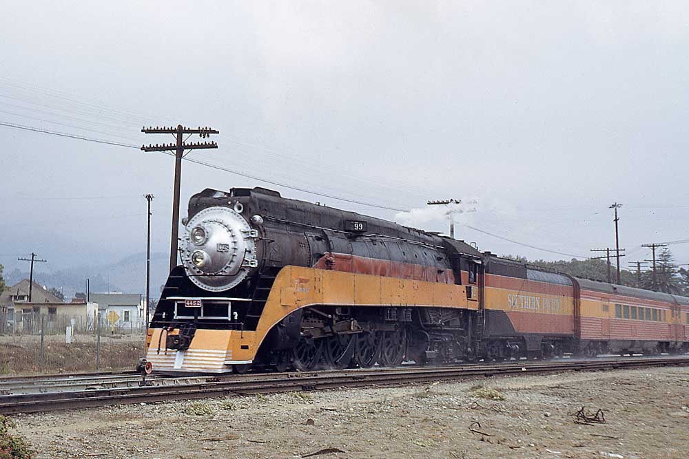 Orange and red streamlined steam locomotive on passenger train