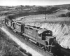 Three diesel locomotives with hopper cars on curve