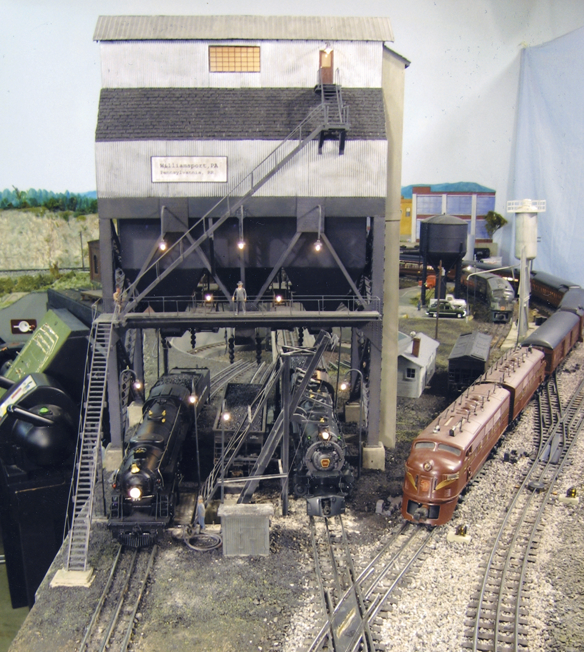 O scale coaling tower with steam engines underneath.