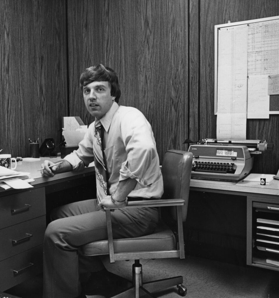 Black-and-white photo of man at a desk