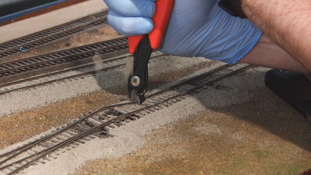 Pieces of flextrack being cut off of layout.