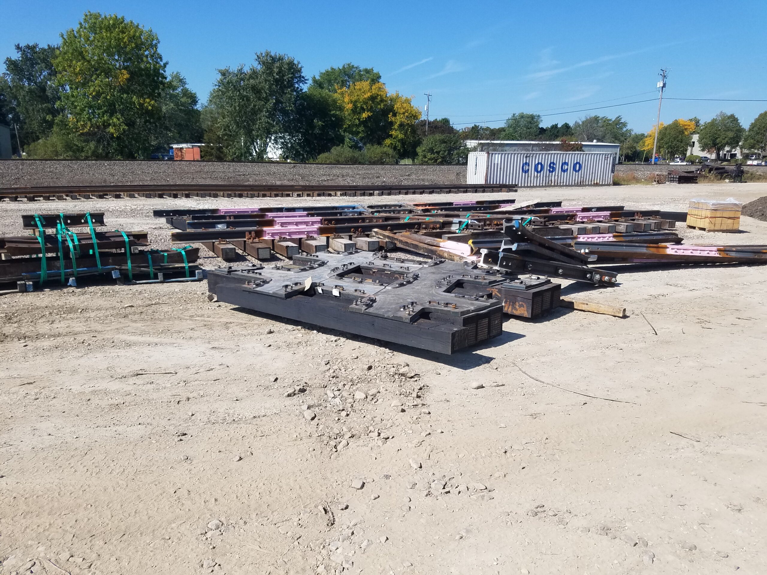 A large steel plate to support one of the crossings is piled with other track components and pieces of rail.