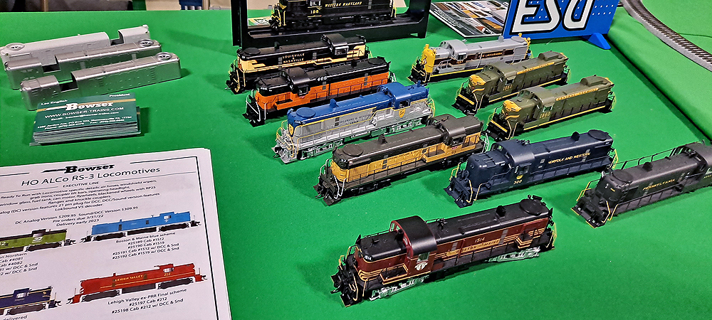 13 HO scale locomotives and shells are displayed on a green tablecloth.