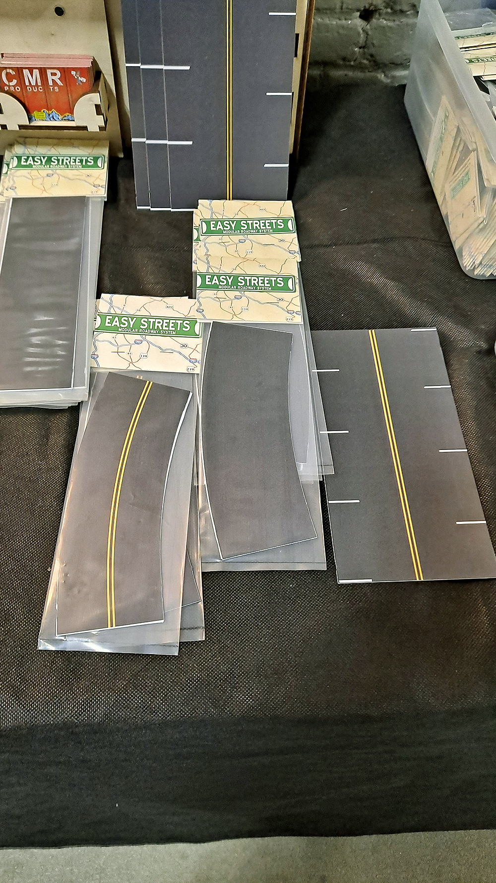 Sections of curved roadway in plastic packaging, straight roadway in stacks.