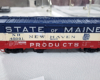 Red, white, and blue State of Maine boxcar with blue roof, white stripe in middle, red stripe at bottom, New Haven lettering in white band.