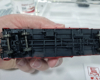Bottom of boxcar painted black showing brake detail and charcoal heater.