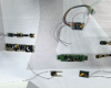 Eight Digital Command Control decoders, some with wire leads, on a white background.