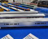 Three silver passenger lounge/café cars on a blue tablecloth.