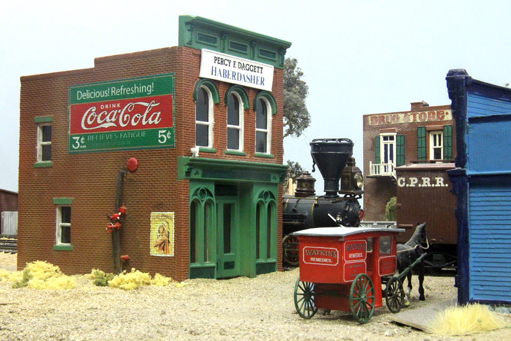 Scene on model railroad with horse-drawn wagon, steam locomotive, and 1890s-style buildings.