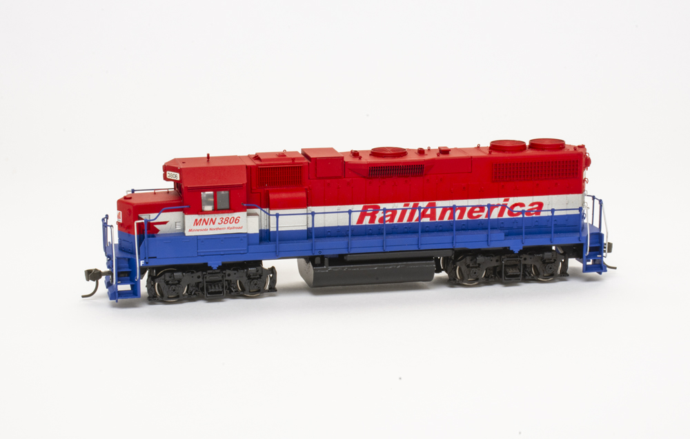 HO scale EMD hood unit painted red, silver, and blue on white background.