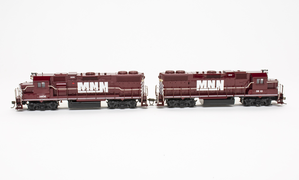 Two HO scale EMD hood units painted maroon with white graphics on a white background.