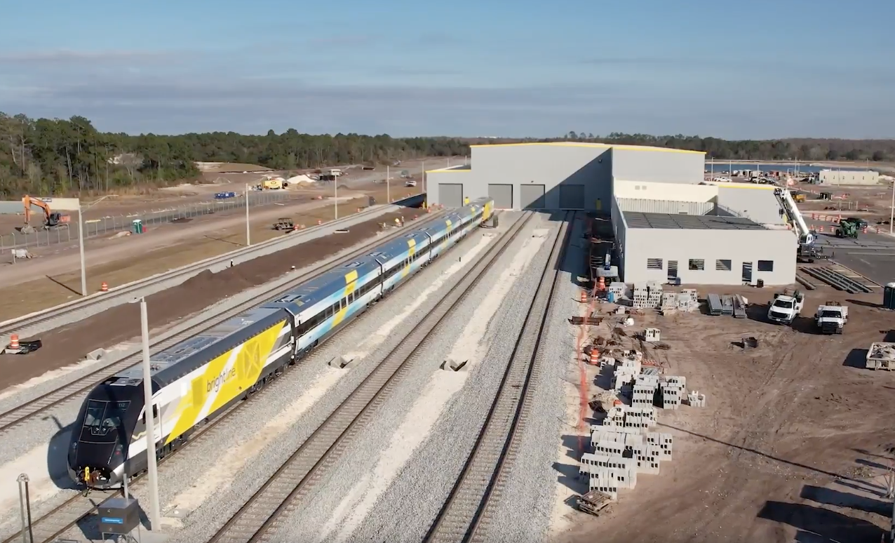 Aerial view of passenger train outside maintenance building