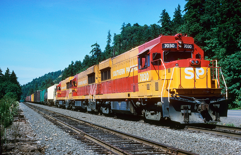 red and yellow locomotives leading mixed train of boxcars