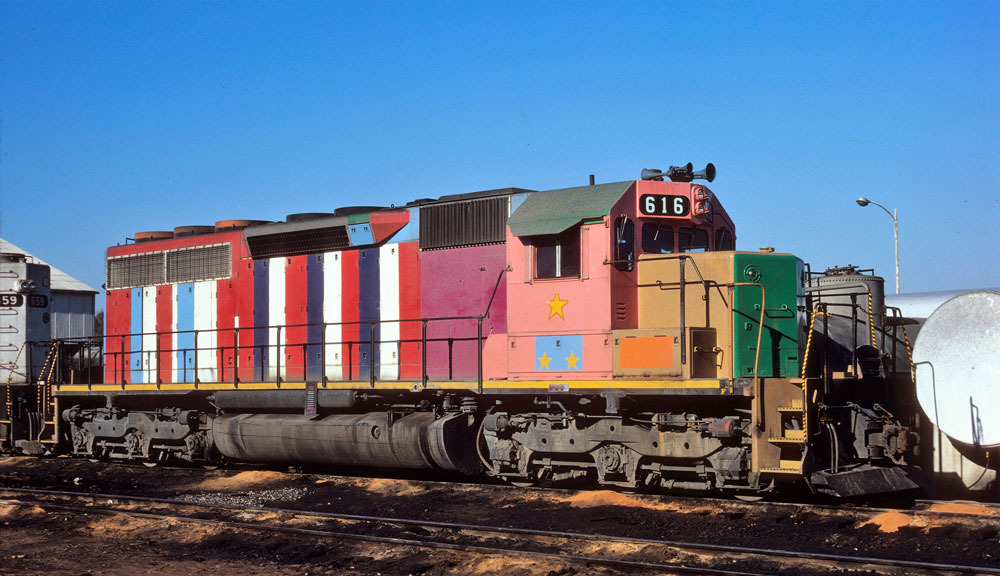 multi color and striped locomotive in red, white blue, maroon, salmon, mustard, and green 