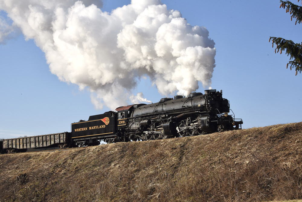 Steam locomotive under large cloud of smoke and steam