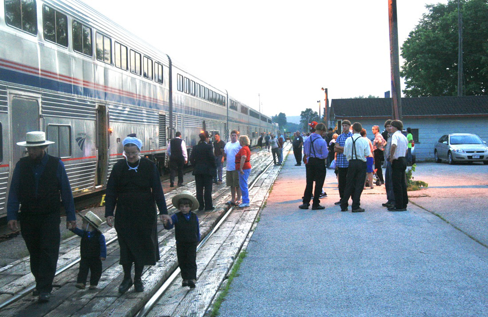 People walking next to Amtrak train at station