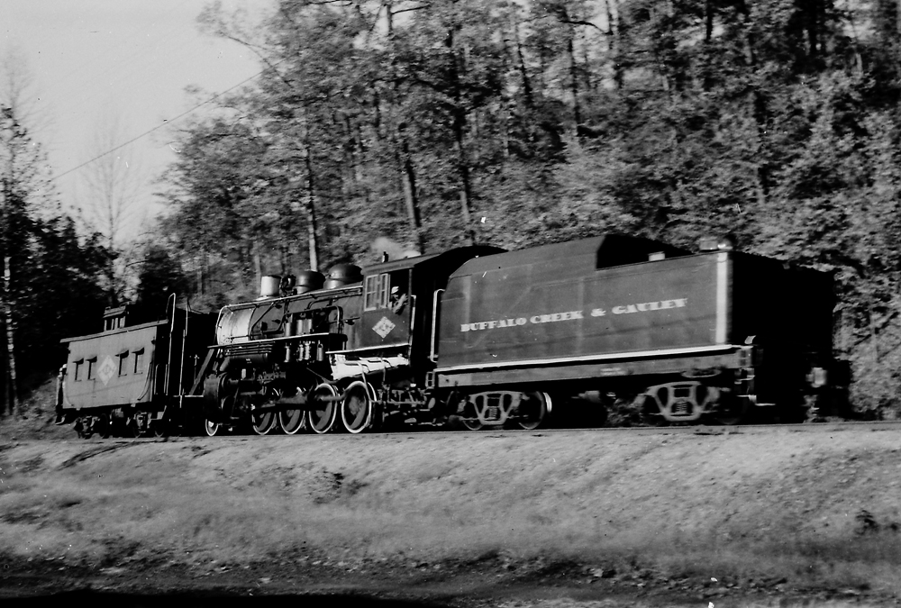 Black and white photo of steam locomotive with caboose