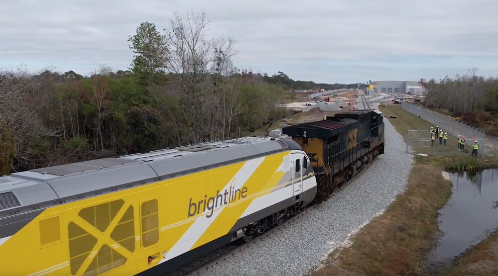 Yellow passenger locomotive pulled by blue freight locomotive