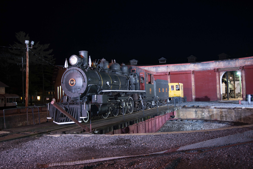 Steam locomotive posed on roundhouse turntable