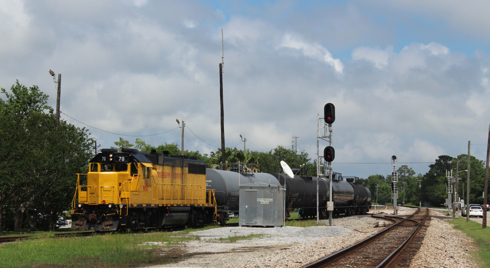 Yellow locomogive moving a short string of freight cars