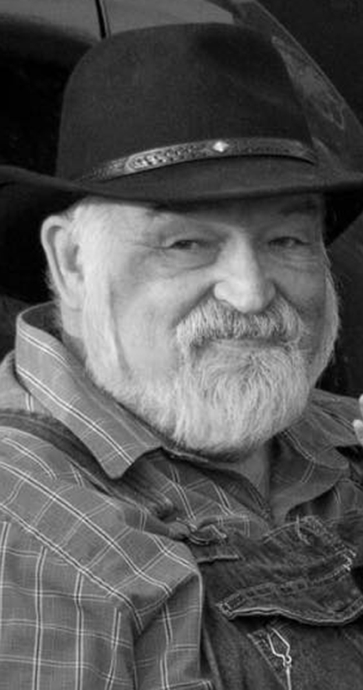 Black and white photo of smiling, bearded man