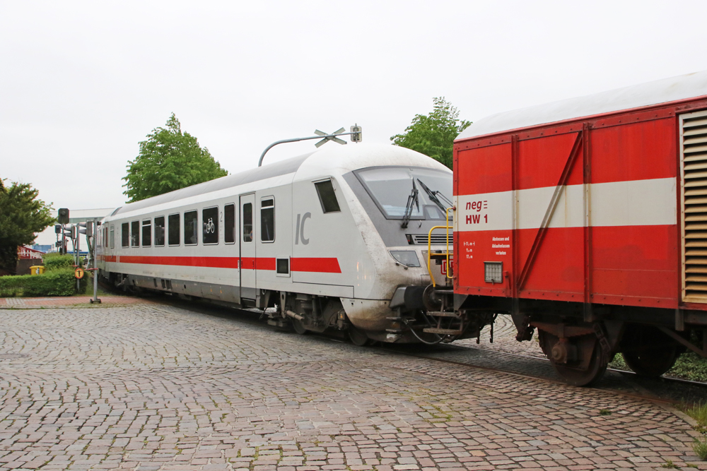 Red-and-white German intercity equipment attached to boxcar