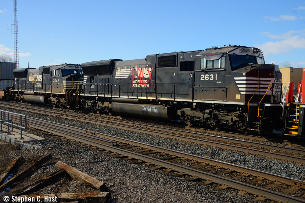 Black locomotives with Norfolk Southern logo crossed out