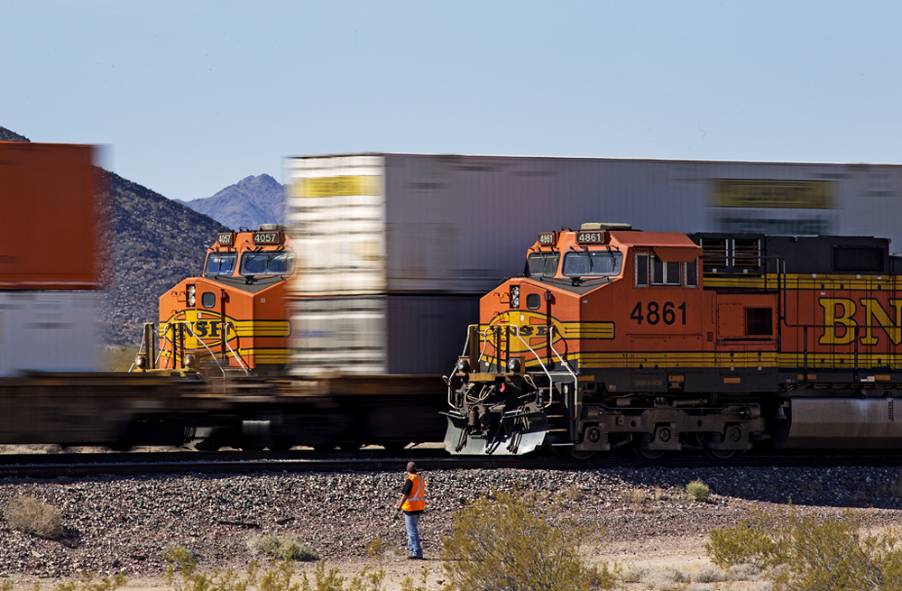 Intermodal train passes between two stopped trains